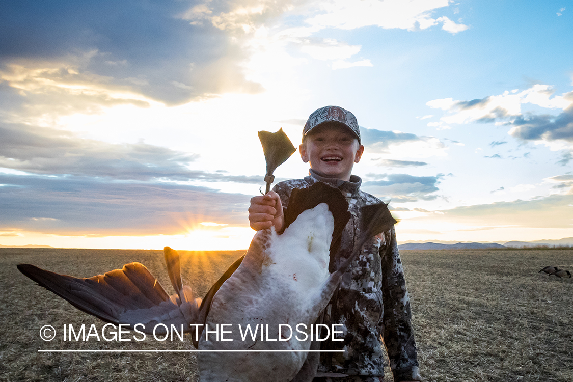 Young hunter with bagged goose. 