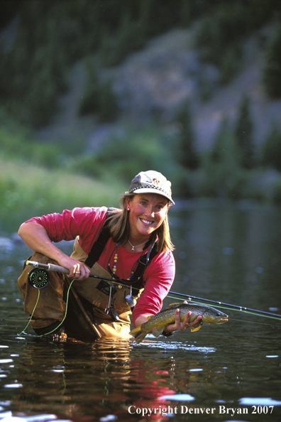 Flyfisher holding/releasing trout.