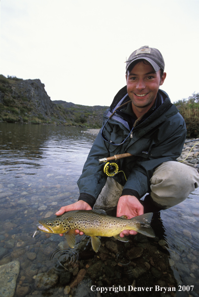 Flyfisherman holding brown trout.