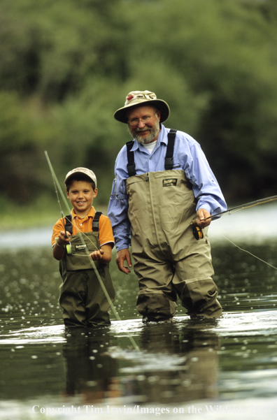 Grandfather teaching grandson how to fish