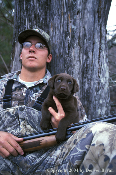 Waterfowl hunter with chocolate Lab pup.