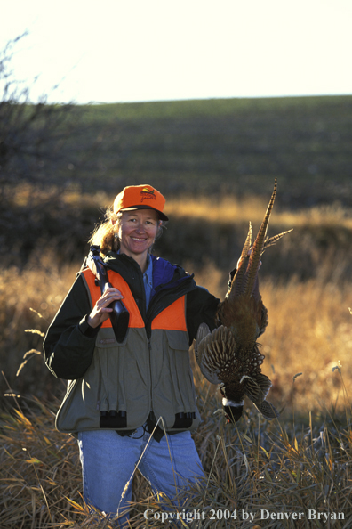 Upland game bird hunter with bagged pheasant.