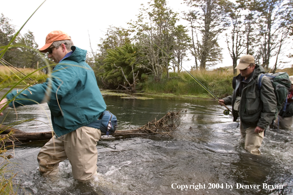 Flyfishermen crossing river.