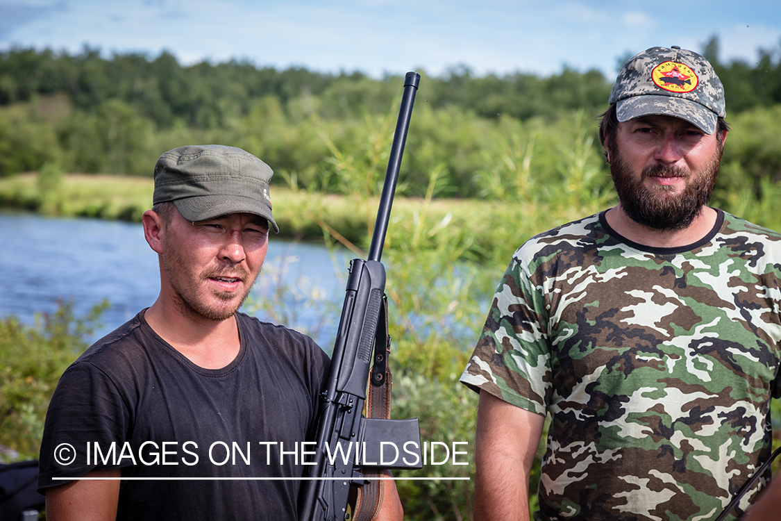 Russian guides with rifle in camp. Flyfishing in Kamchatka Peninsula, Russia.