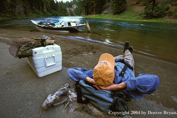 Flyfisherman taking a break on shore.