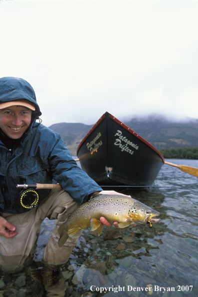 Flyfisherman holding brown trout.