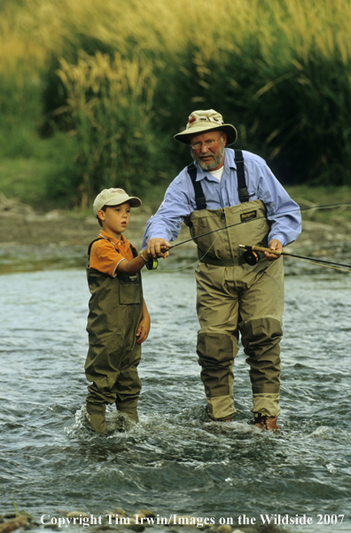 Grandfather teaching grandson how to fish