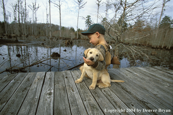 Young hunter with yellow Lab pup.