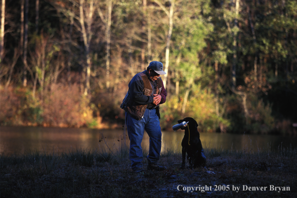 Trainer with black Labrador Retriever.