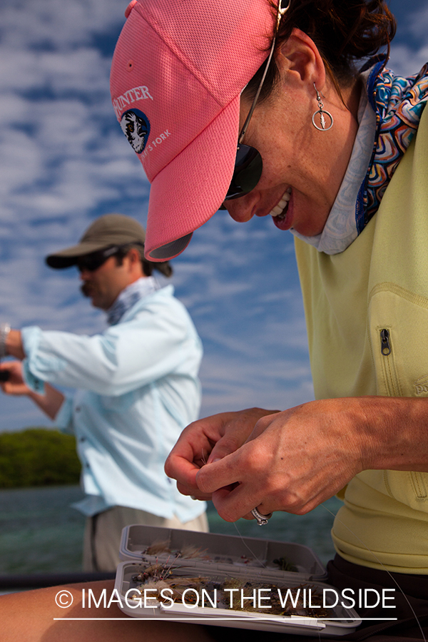 Flyfishing woman tying fly.