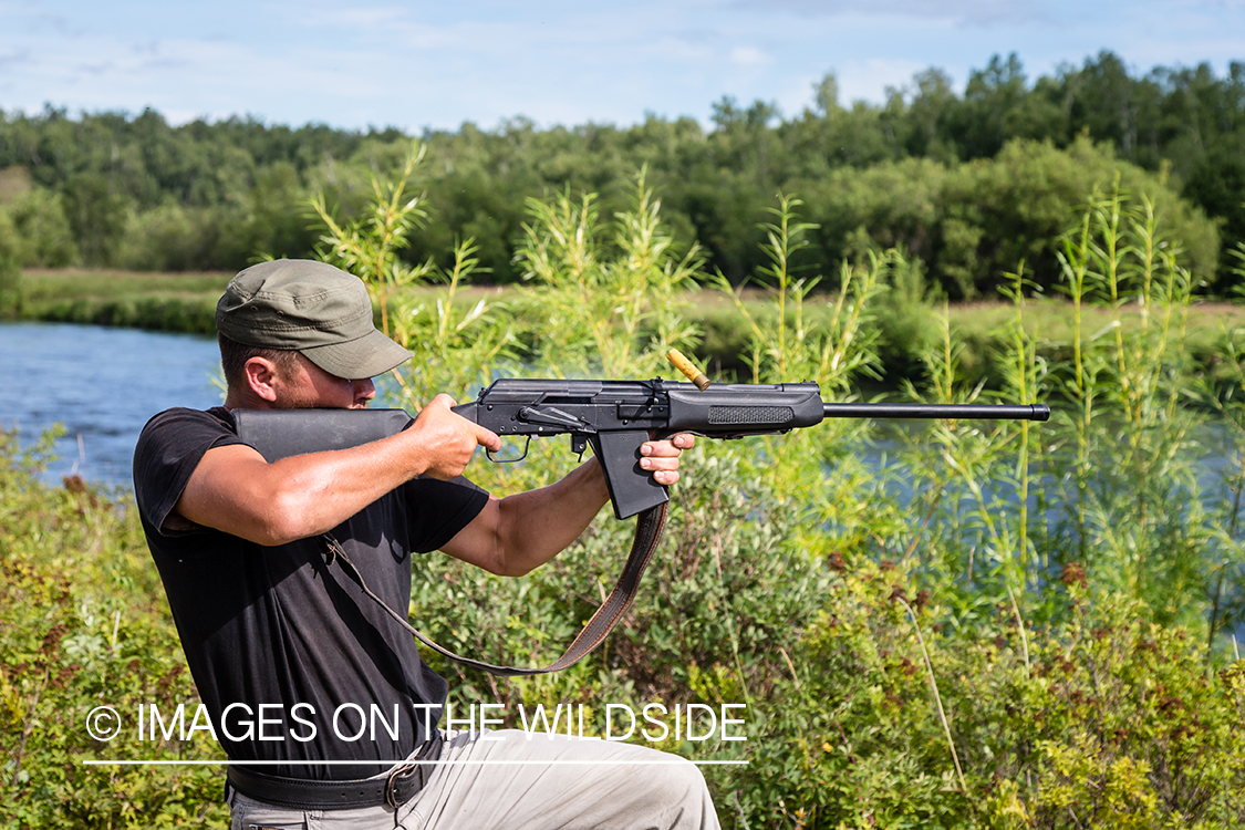 Russian guide shooting rifle in Kamchatka Peninsula, Russia.