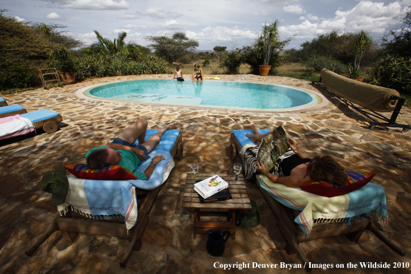 Family around pool on safari