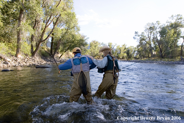 Flyfishermen walking across river.