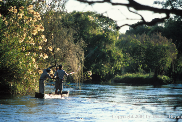 Flyfisherman and guide fishing from dugout / mekoro. 