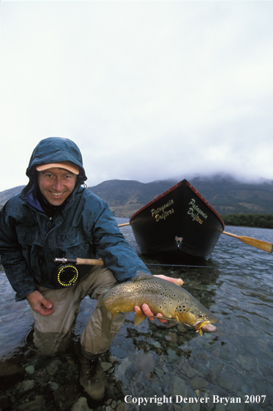 Flyfisherman holding brown trout.