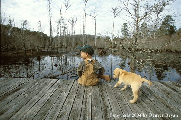 Young hunter with yellow Lab pup.