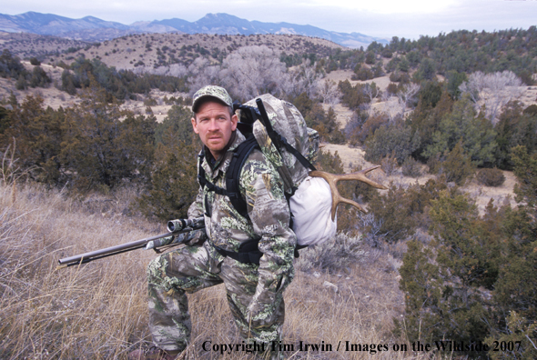 Big game hunter with mule deer horns on back.