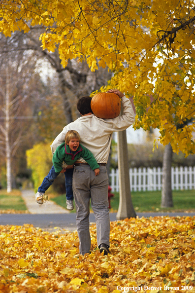 Father Carrying Child and Pumpkin