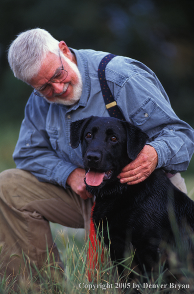 Trainer with black Labrador Retriever.