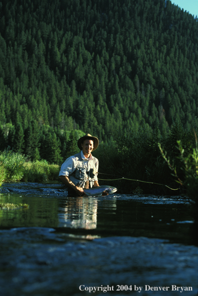 Flyfisherman holding rainbow trout.