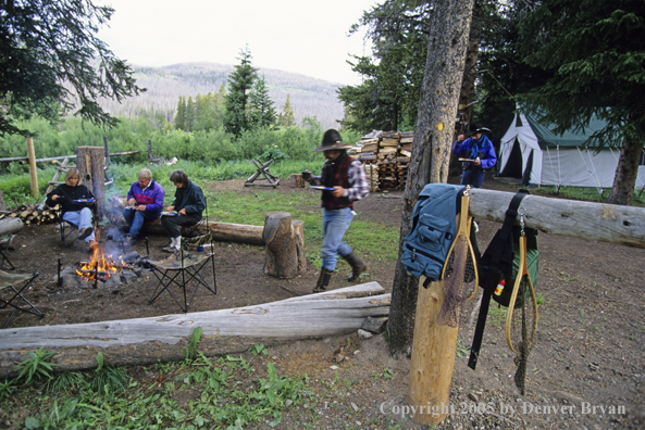 Cowboys and campers sitting around campfire.