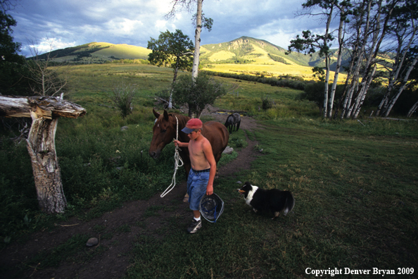 Young horseback rider with dog