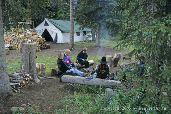 Cowboys and campers sitting around campfire.