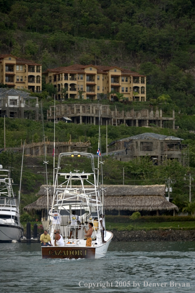 Deep sea fishing charter boat heading out of marina.