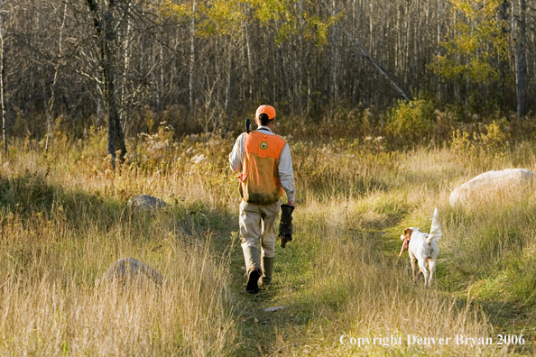 Upland bird hunter in field with dog.