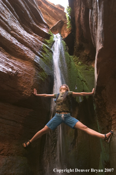 Hikers exploring feeder stream/waterfall of the Colorado River.  Grand Canyon.