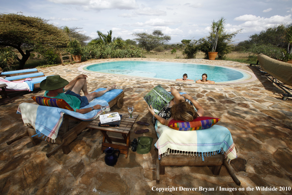 Family around pool on safari