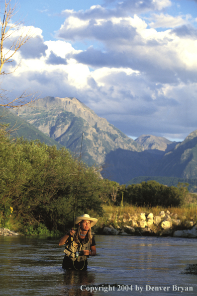 Woman flyfisher fishing river.