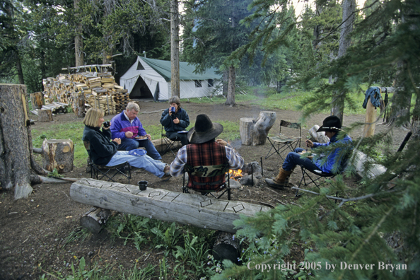 Cowboys and campers sitting around campfire.