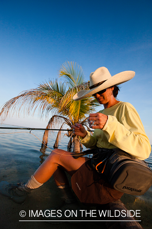 Flyfishing woman tying fly.