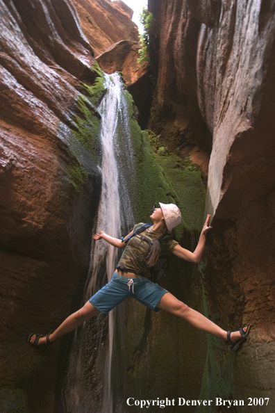 Hiker exploring feeder stream/waterfall of the Colorado River.  Grand Canyon.