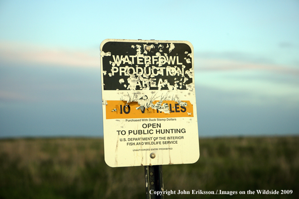 Sign posted on wetlands all shot up