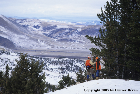 Father and son hunters big game hunting in a field in winter.