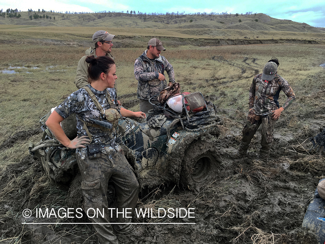 Hunters with ATV stuck in rain soaked field. 