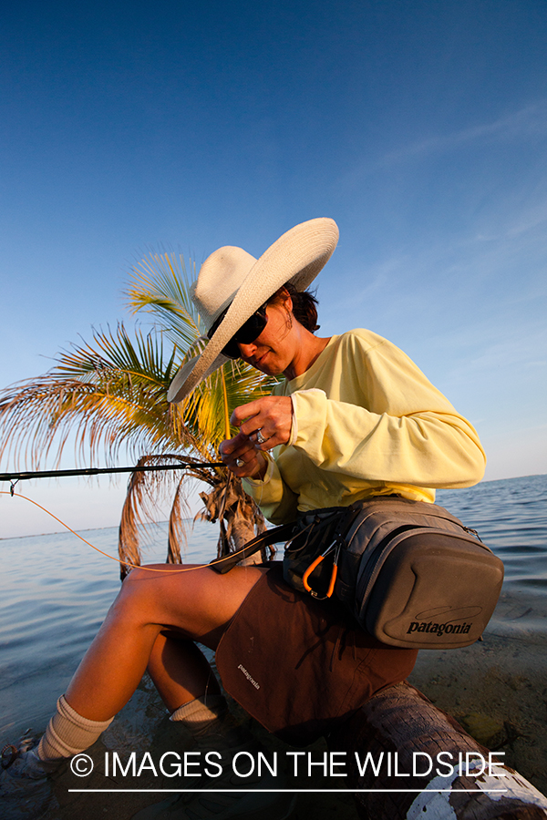 Flyfishing woman tying fly.