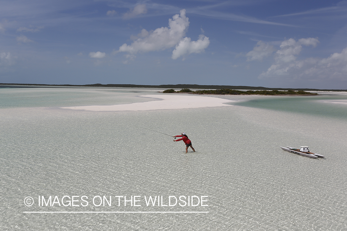 Saltwater flyfishing woman with stand up paddle board fishing flats.