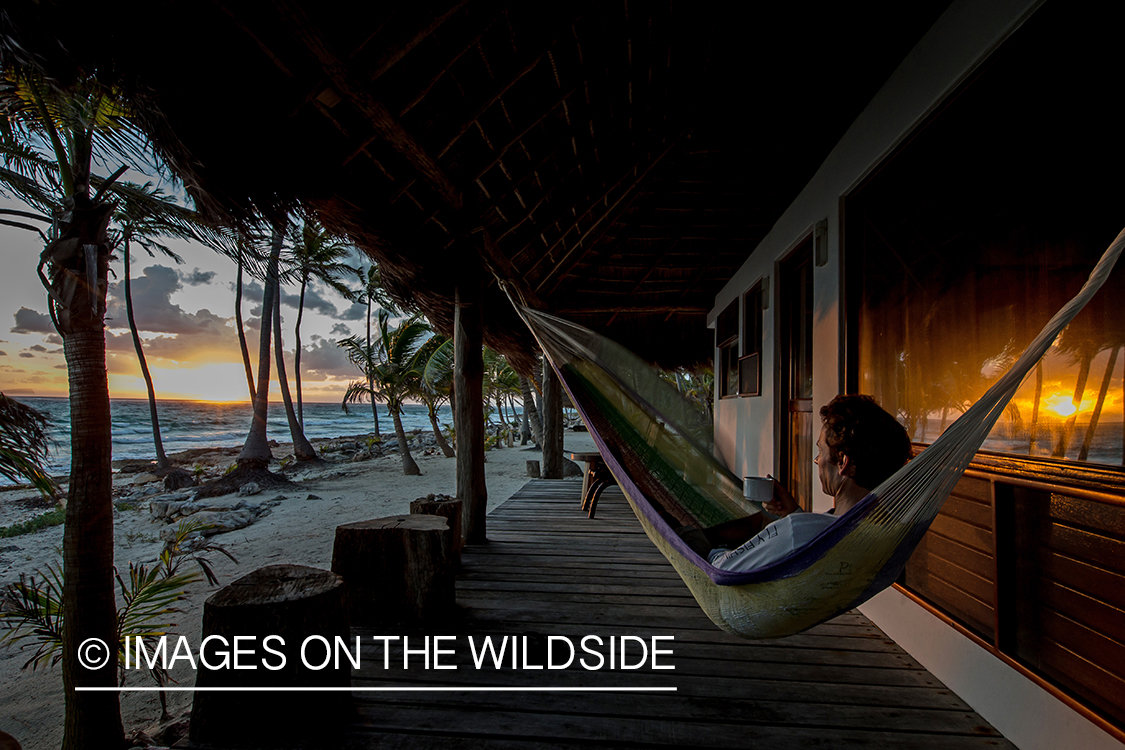 Flyfisherman relaxing in hammock at sunset.