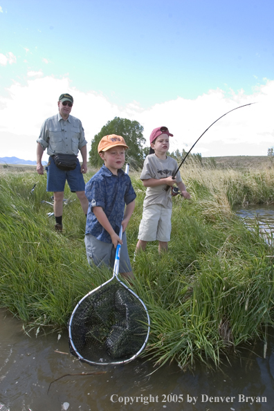 Father watching sons fighting/landing trout.