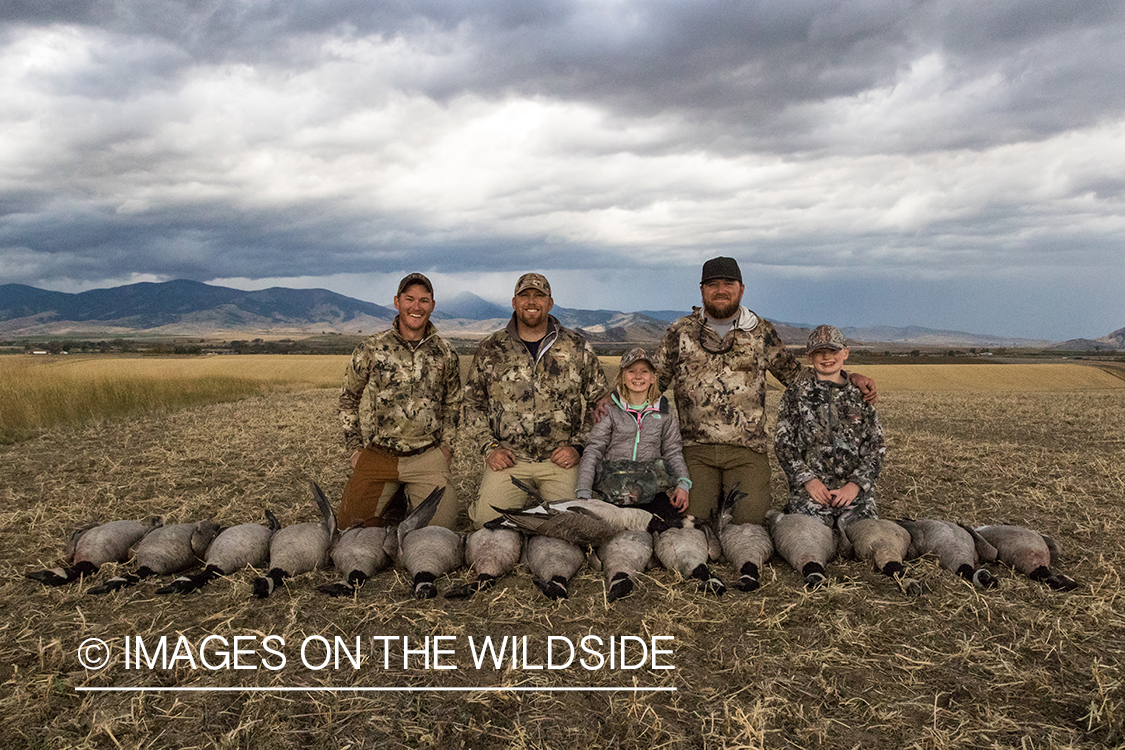 Family of hunters with bagged Canada geese.