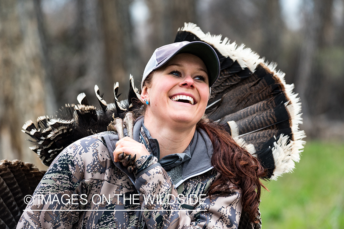 Woman hunter with bagged turkey.