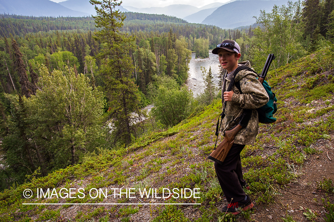 Boy with rifle on Nakina River, British Columbia.