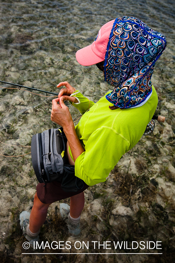 Flyfishing woman tying fly.