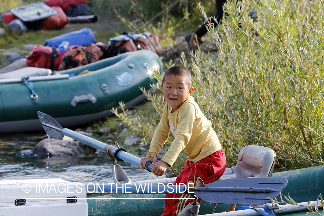 Mongolian boy in float raft on Delger River, Mongolia.