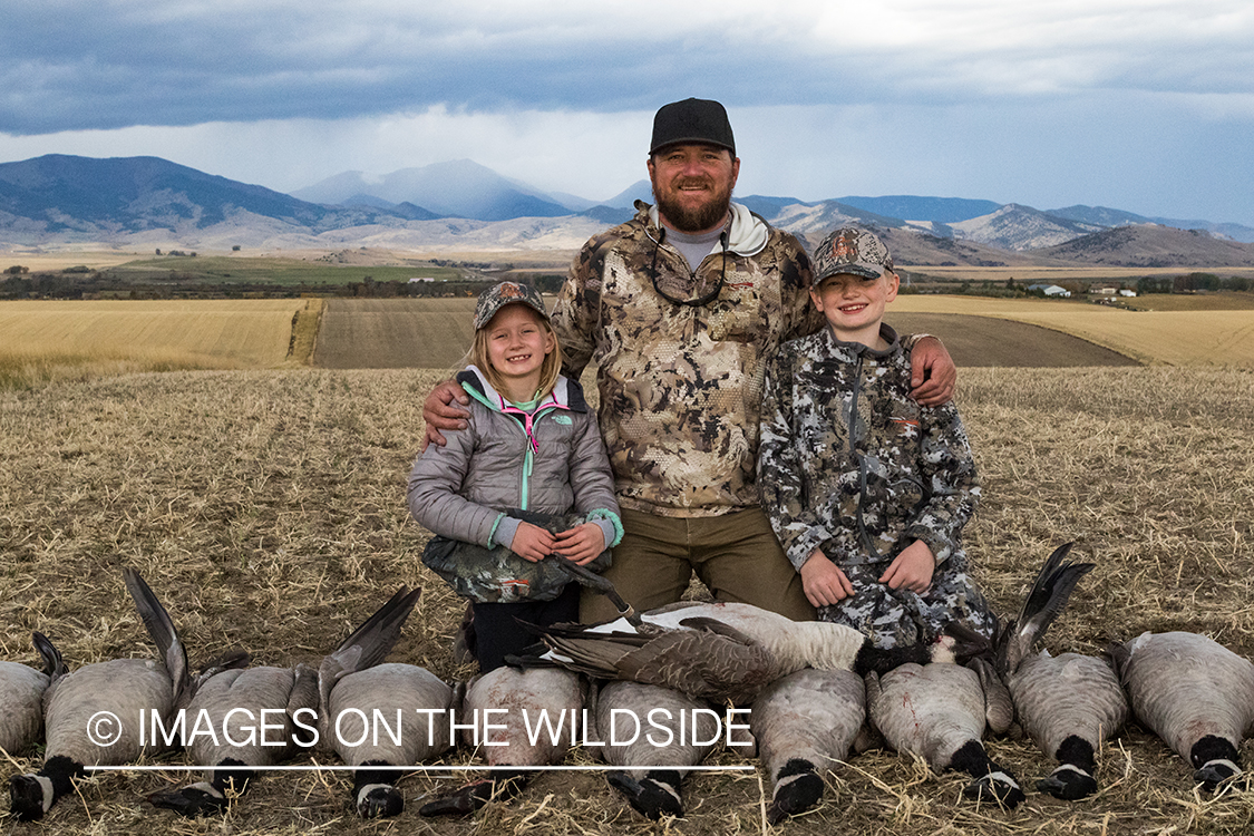 Family of hunters with bagged Canada geese.