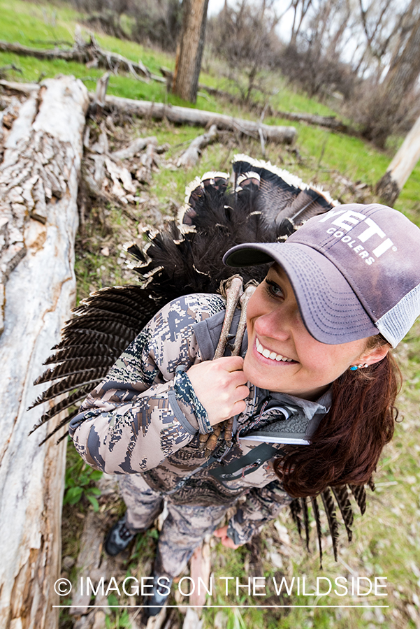 Woman hunter with bagged turkey.