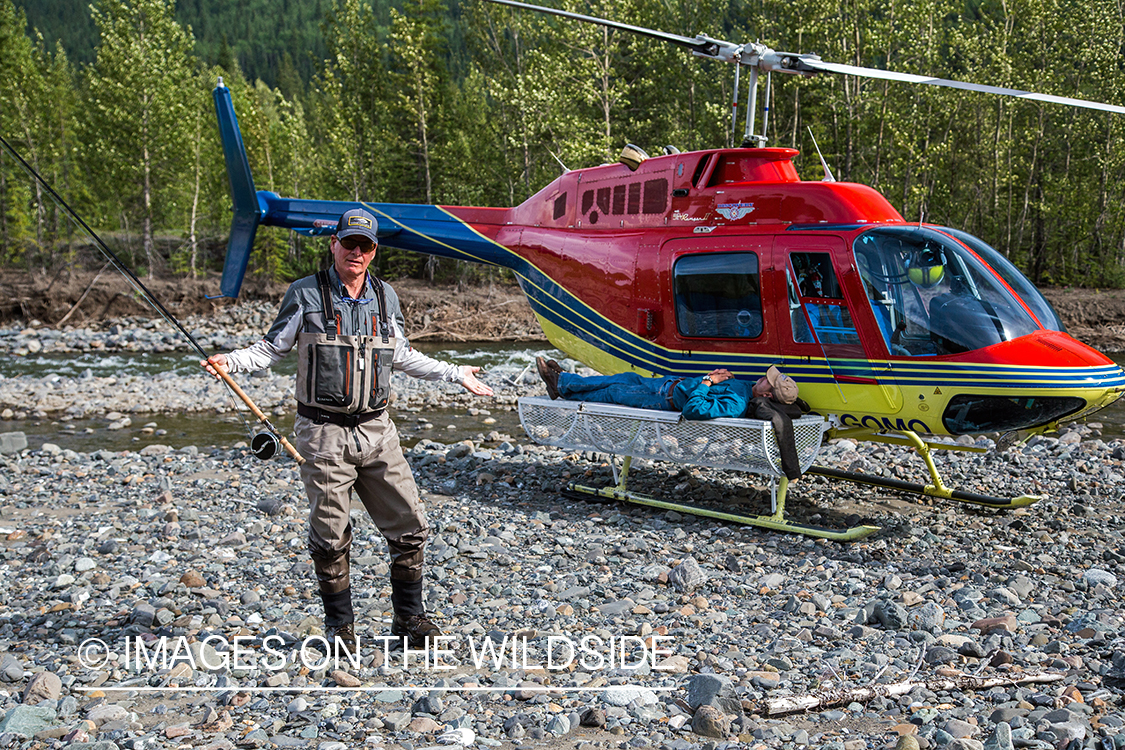 Flyfisherman next to helicopter.